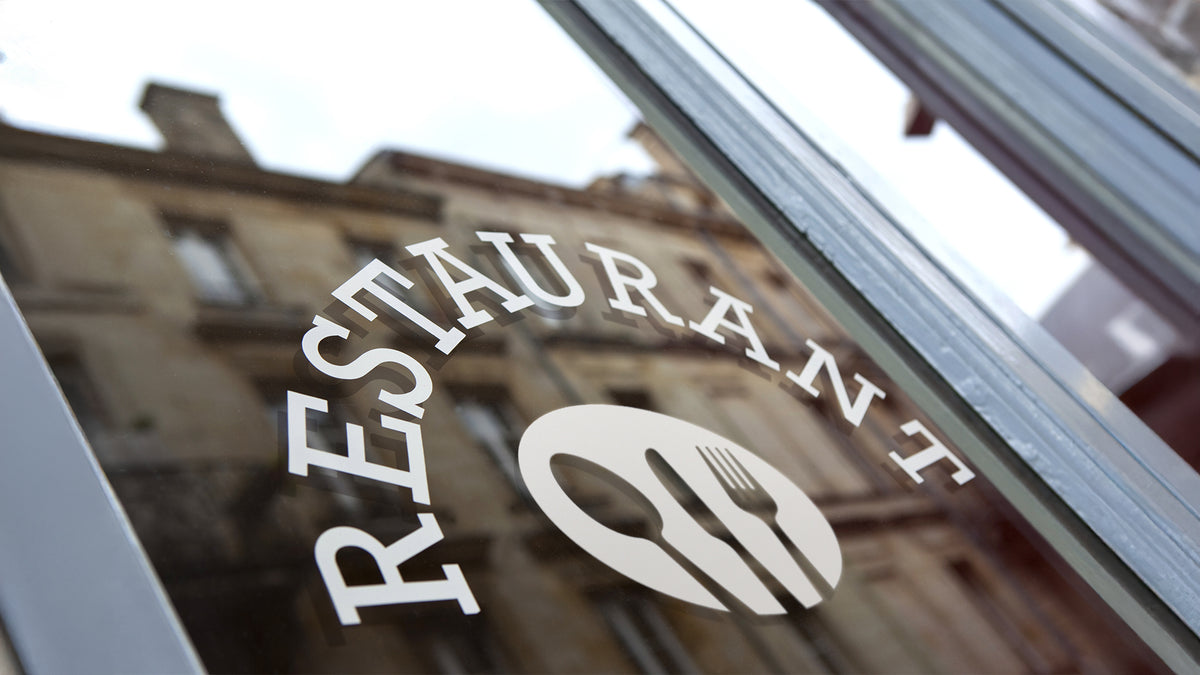 Cut adhesive vinyl lettering and logo applied directly to storefront glass