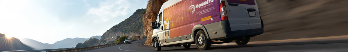 Wide view of a wrapped cargo van in motion on a coastal road