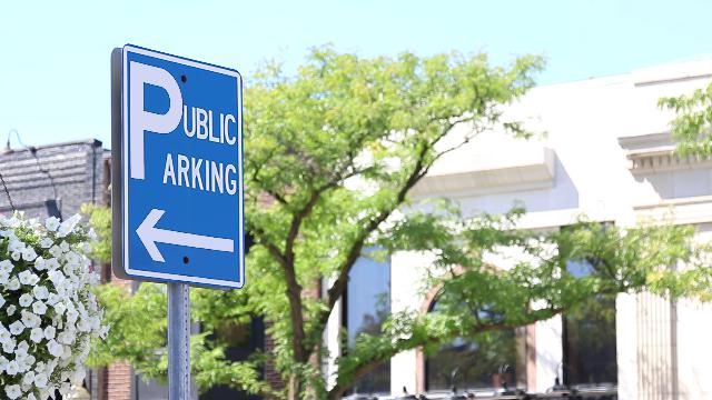 Aluminum sign mounted on a metal pole as a directional parking sign in a downtown streetscape