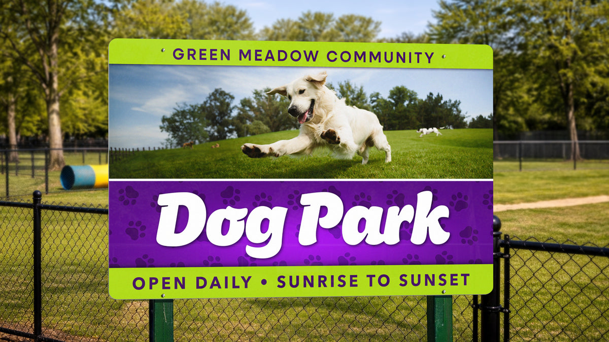 Large full-color aluminum sign with rounded corners, bolted to posts at a fenced park entrance