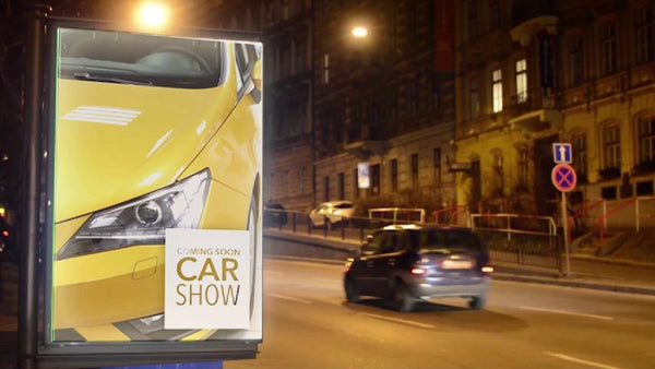 Backlit sign film in an illuminated street-side light box at night