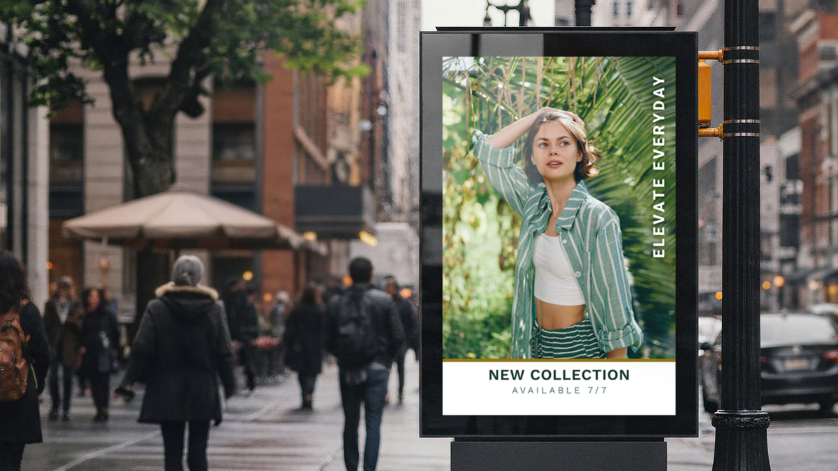 Backlit poster film in an illuminated sidewalk light box on a city street