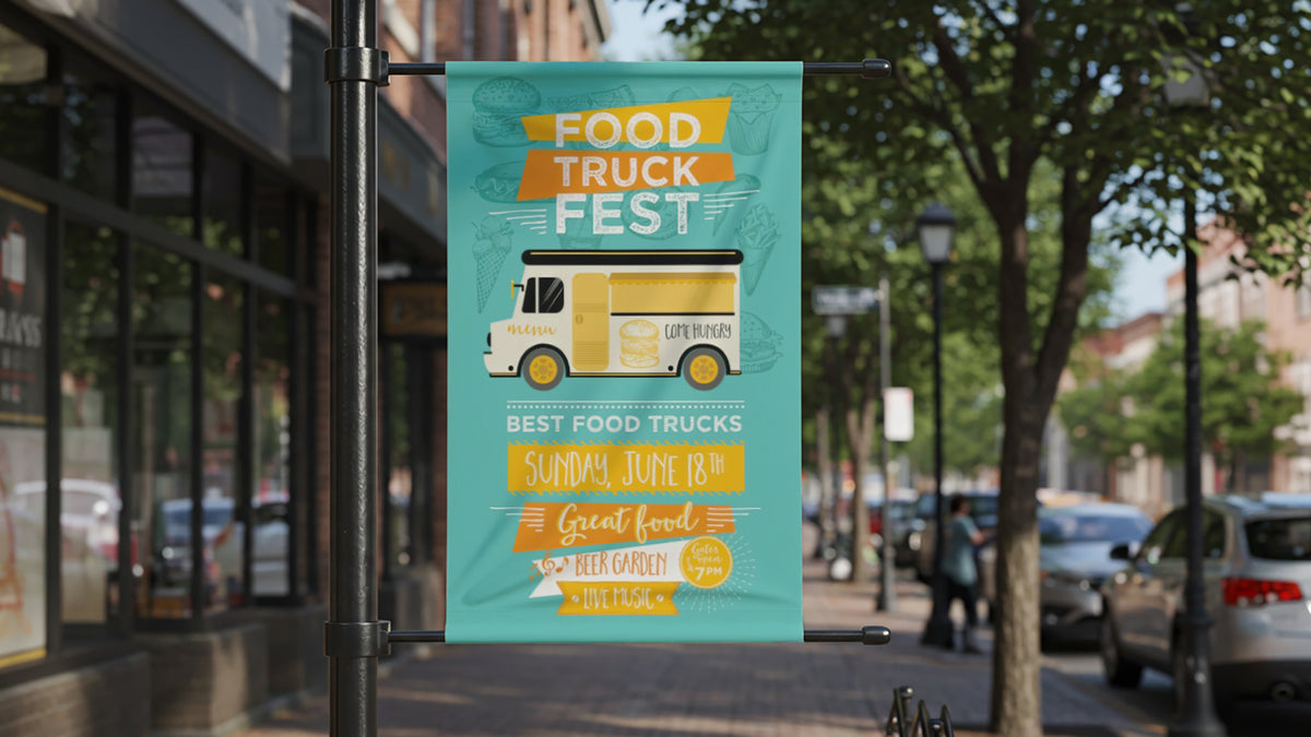 Vertical vinyl pole banner held top and bottom by street-pole brackets on a downtown sidewalk