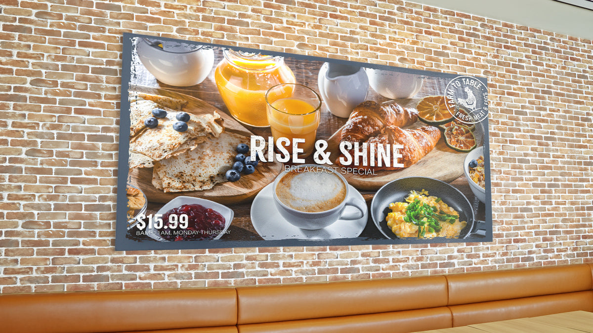 Large promotional poster mounted flat to a brick wall above restaurant seating